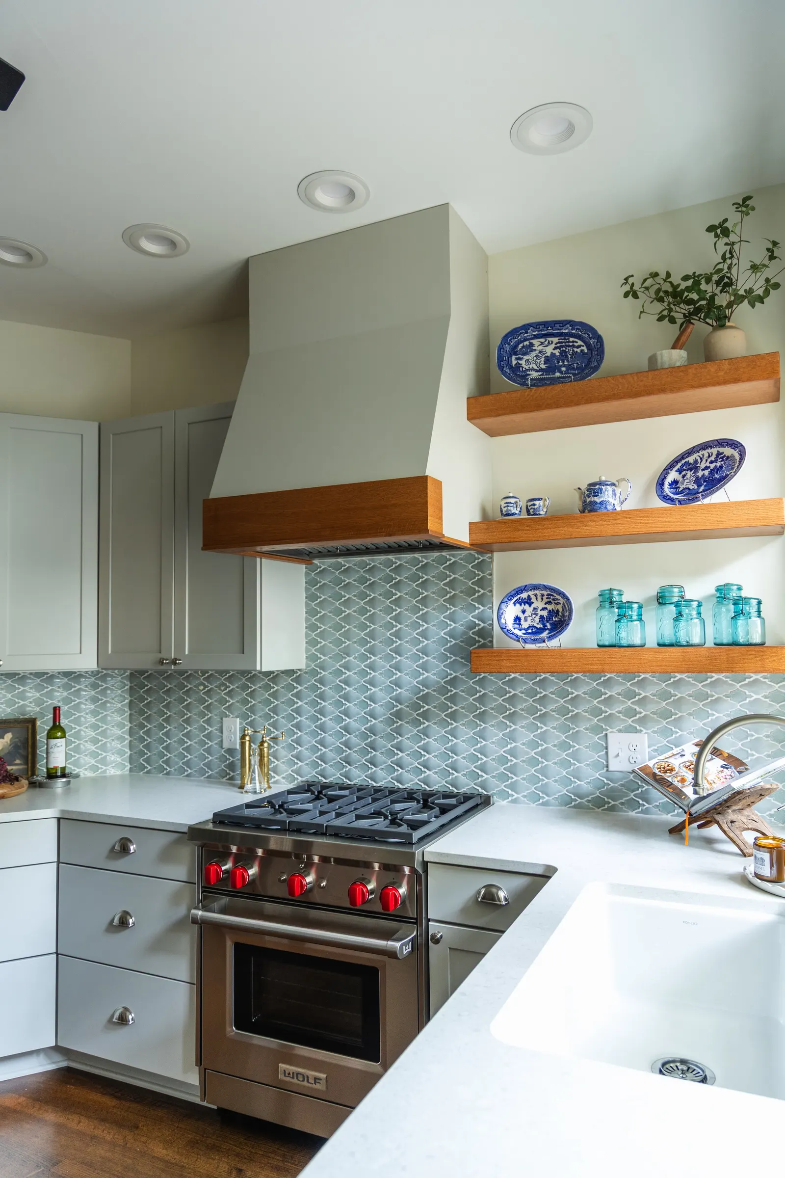 1900 Kitchen Remodel, wood floors, light blue tile backsplash, hardwood floors, open shelving, brushed nickel hardware, wolf oven, stainless steel appliances, custom hood, custom cabinetry, Omaha Nebraska, remodeling and renovations.