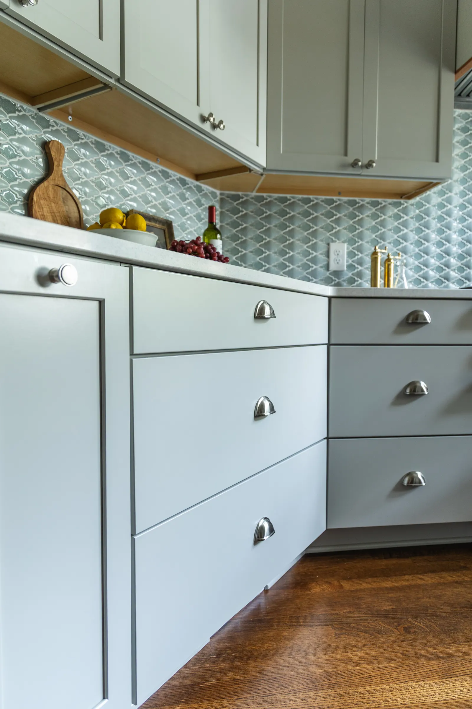 1900 Kitchen Remodel, wood floors, light blue tile backsplash, hardwood floors, open shelving, brushed nickel hardware, wolf oven, stainless steel appliances, custom hood, custom cabinetry, Omaha Nebraska, remodeling and renovations.