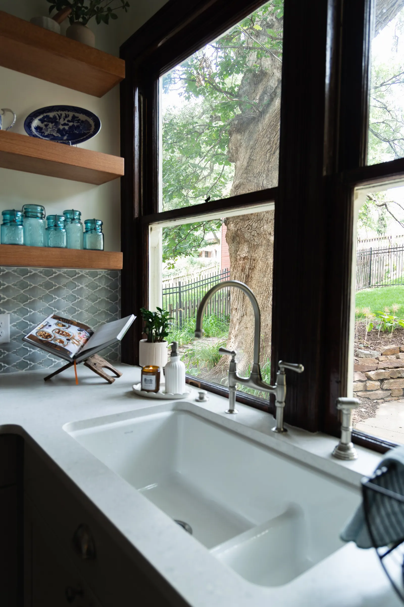 1900 Kitchen Remodel, wood floors, light blue tile backsplash, hardwood floors, open shelving, brushed nickel hardware, wolf oven, stainless steel appliances, custom hood, custom cabinetry, Omaha Nebraska, remodeling and renovations.