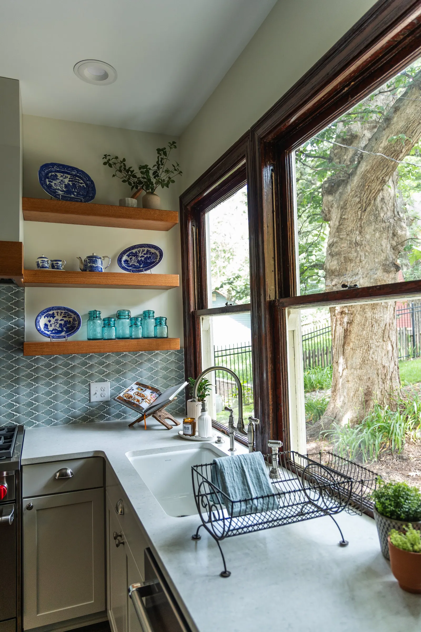1900 Kitchen Remodel, wood floors, light blue tile backsplash, hardwood floors, open shelving, brushed nickel hardware, wolf oven, stainless steel appliances, custom hood, custom cabinetry, Omaha Nebraska, remodeling and renovations.