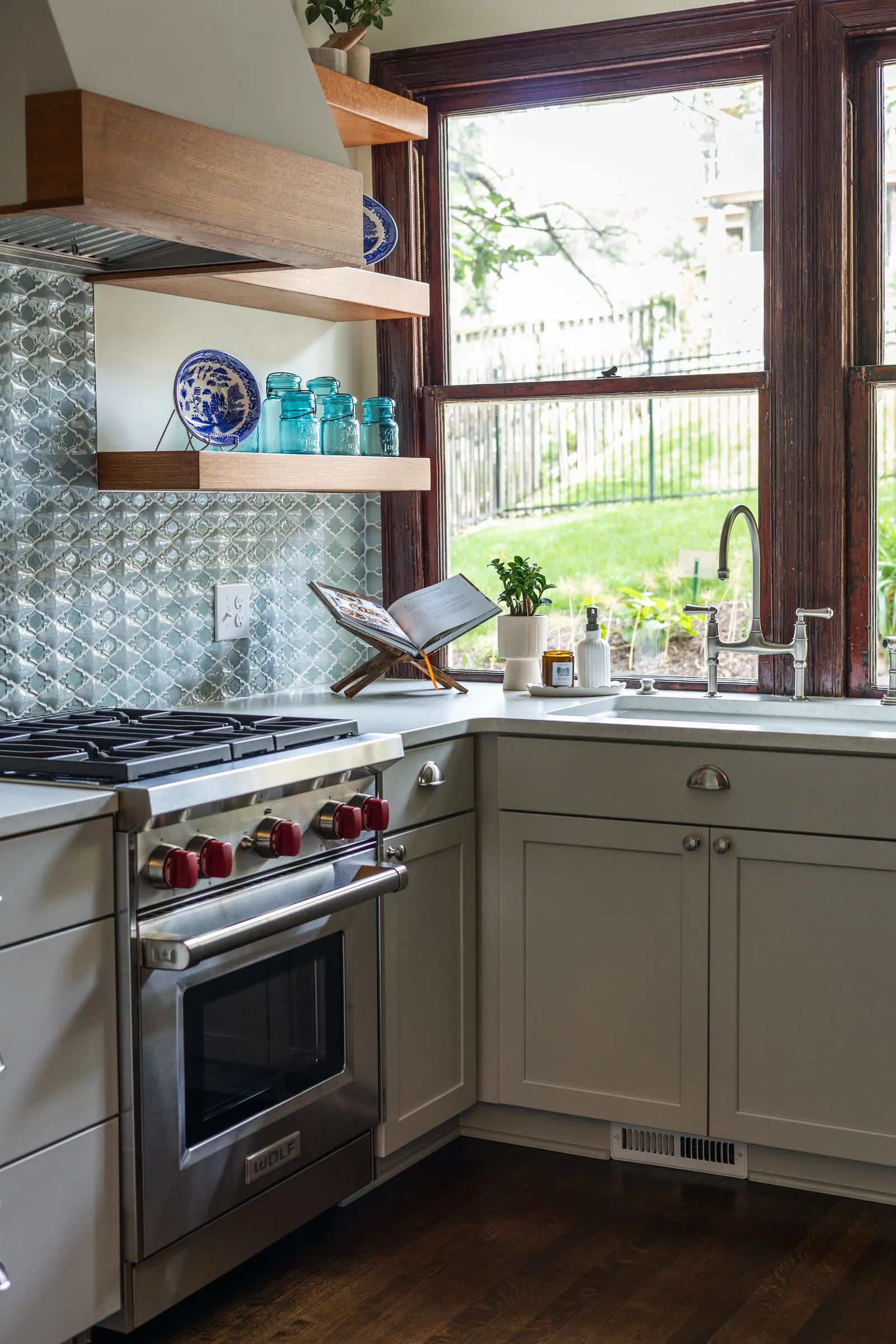 1900 Kitchen Remodel, wood floors, light blue tile backsplash, hardwood floors, open shelving, brushed nickel hardware, wolf oven, stainless steel appliances, custom hood, custom cabinetry, Omaha Nebraska, remodeling and renovations.
