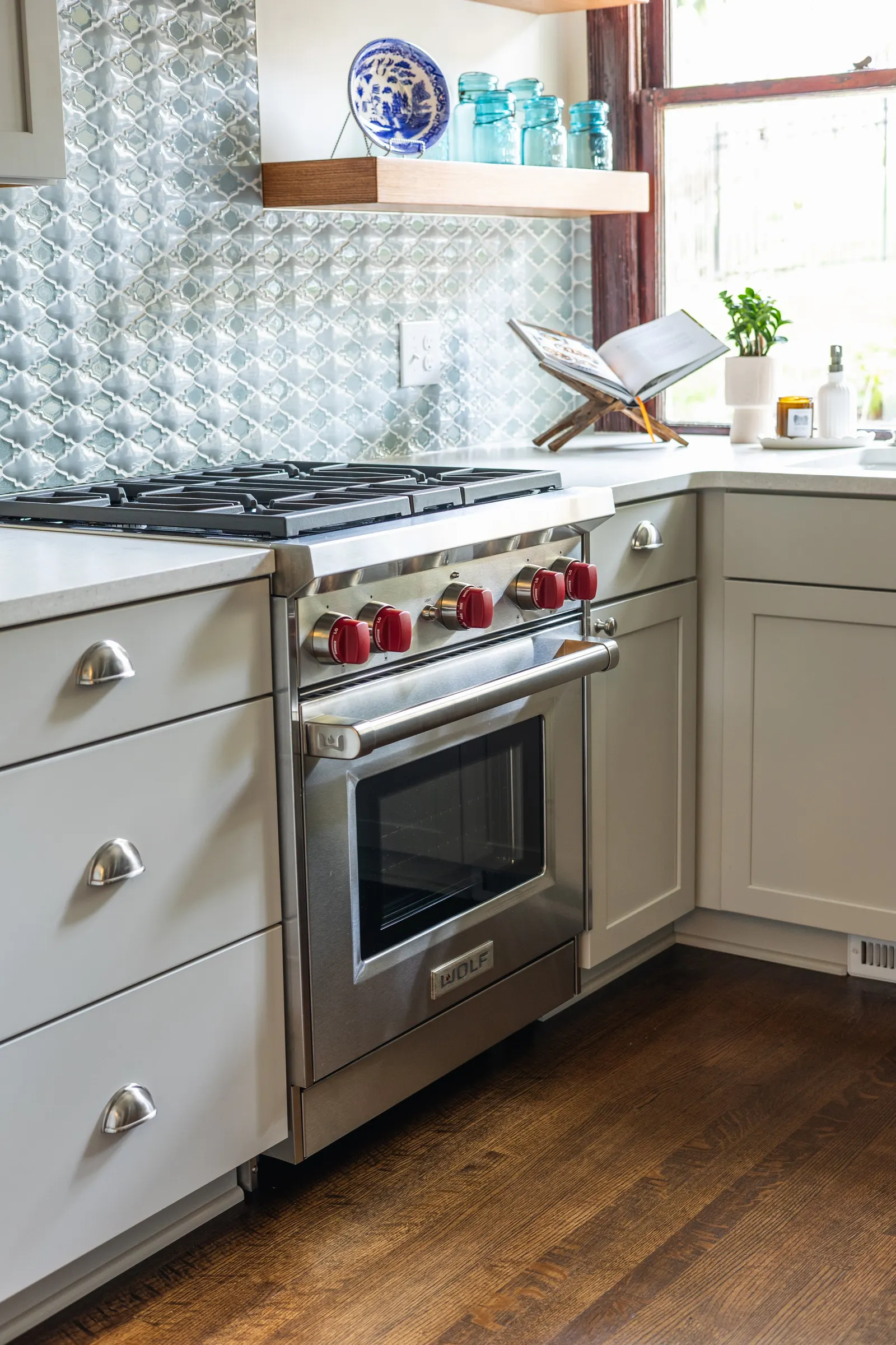 1900 Kitchen Remodel, wood floors, light blue tile backsplash, hardwood floors, open shelving, brushed nickel hardware, wolf oven, stainless steel appliances, custom hood, custom cabinetry, Omaha Nebraska, remodeling and renovations.