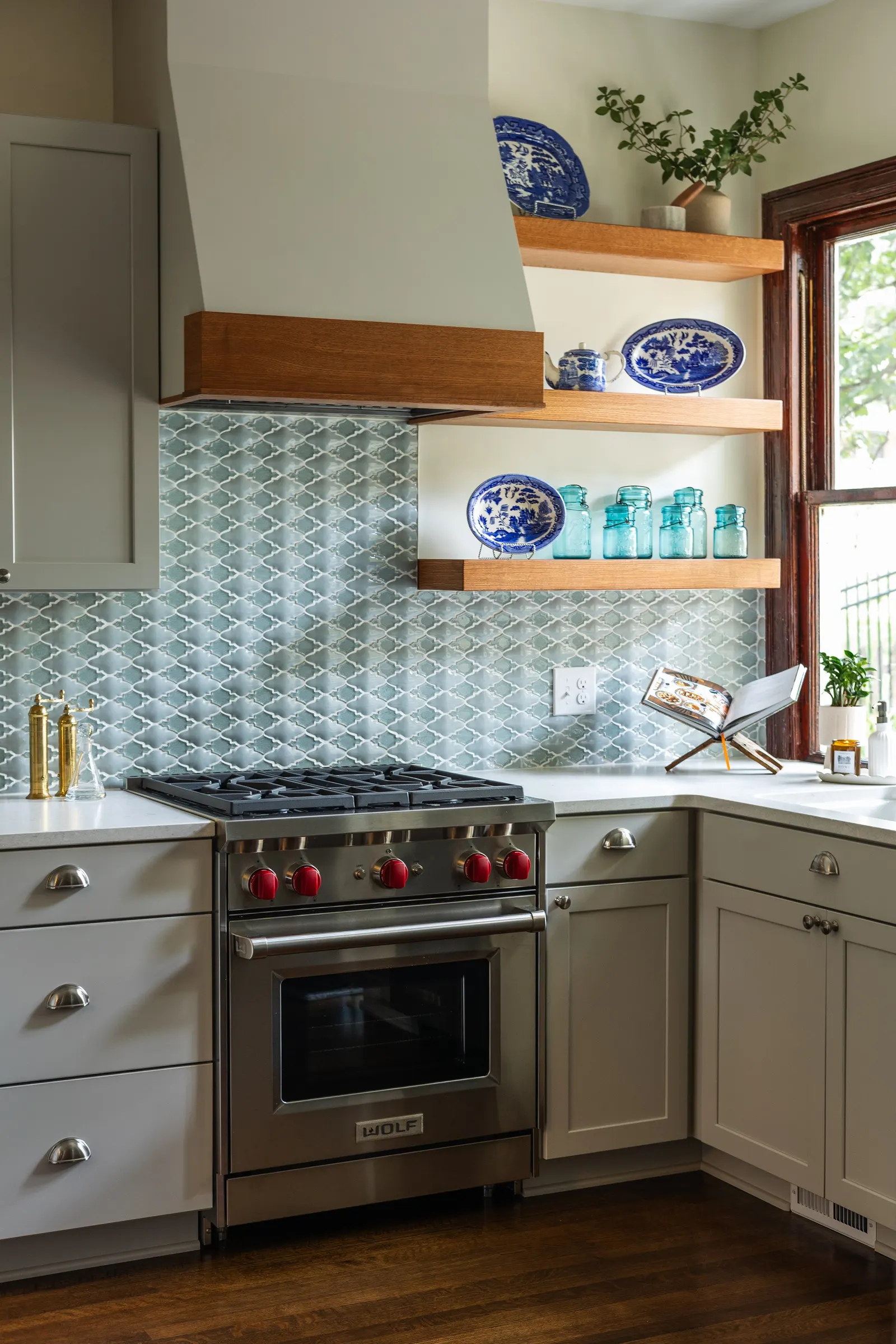 1900 Kitchen Remodel, wood floors, light blue tile backsplash, hardwood floors, open shelving, brushed nickel hardware, wolf oven, stainless steel appliances, custom hood, custom cabinetry, Omaha Nebraska, remodeling and renovations.