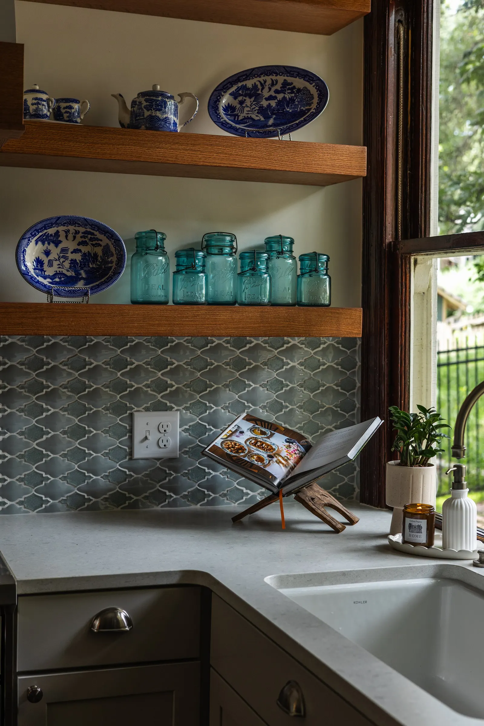 1900 Kitchen Remodel, wood floors, light blue tile backsplash, hardwood floors, open shelving, brushed nickel hardware, wolf oven, stainless steel appliances, custom hood, custom cabinetry, Omaha Nebraska, remodeling and renovations.
