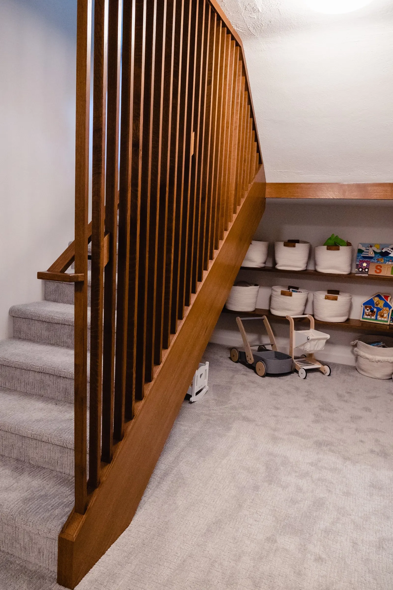 1922 Basement Remodel, carpet, brick fireplace, custom wood mantel, white cabinets, matte black hardware, matte black sconces, open shelves, floating wood shelves, custom woodworking, Lincoln Nebraska, professional contractors, craftsmanship.