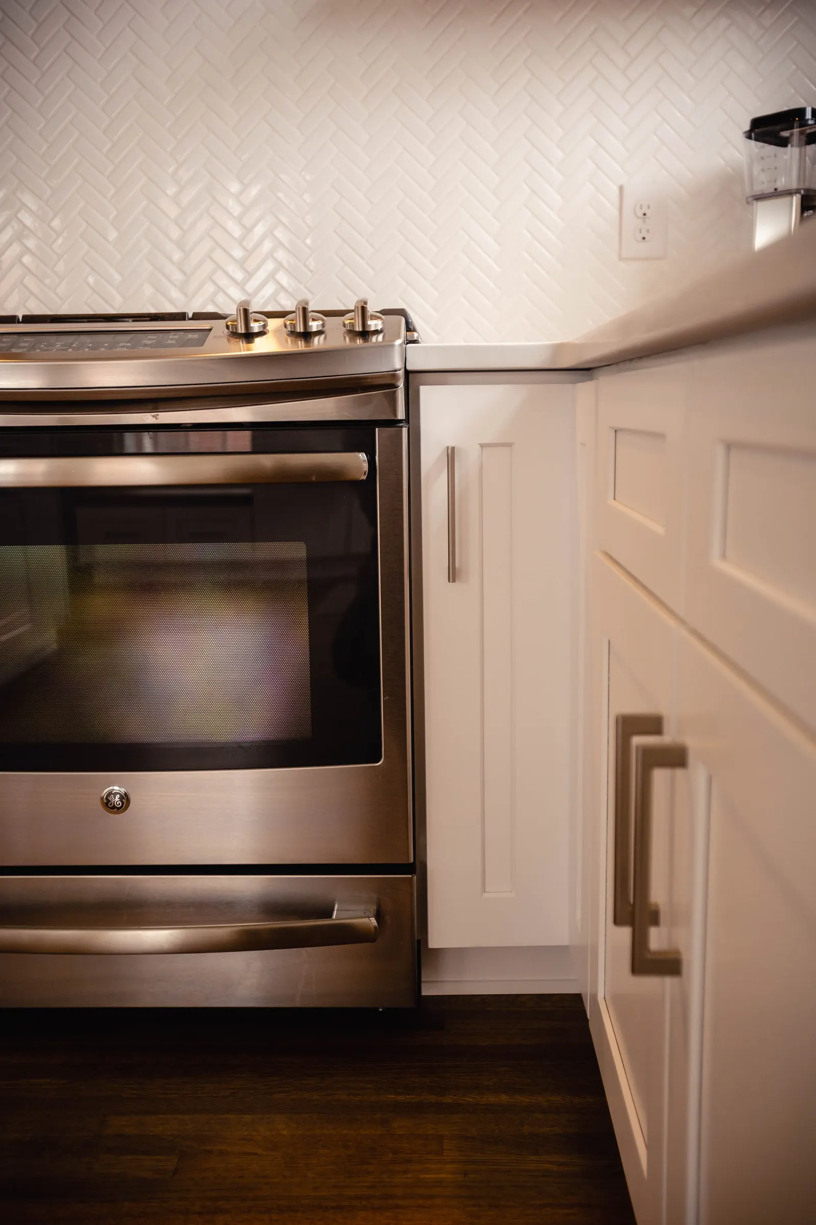 1922 Kitchen Remodel, Whole Home Remodel, brushed nickel hardware, white herringbone backsplash, custom white cabinets, wood floors, stainless steel appliances, white quartz countertops, open shelving, Lincoln Nebraska, professional contractors.