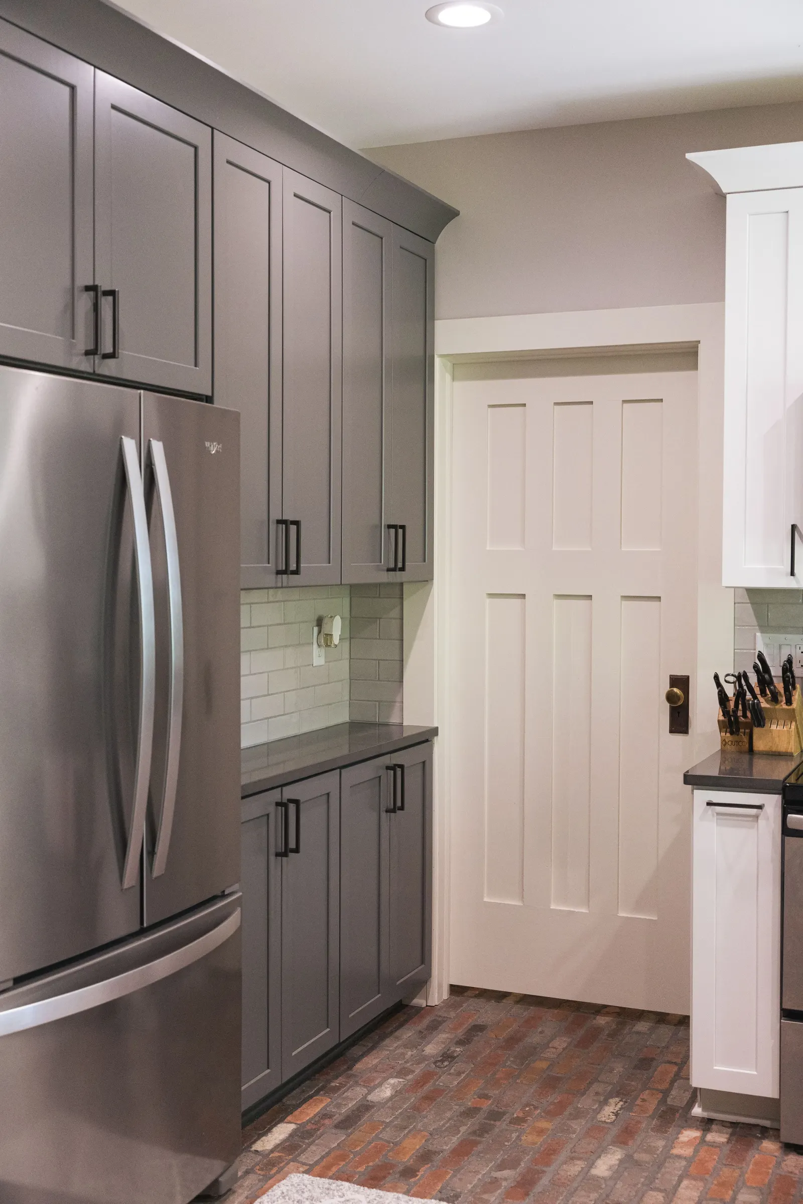 A wall of gray cabinets built around the refrigerator, running floor to ceiling.