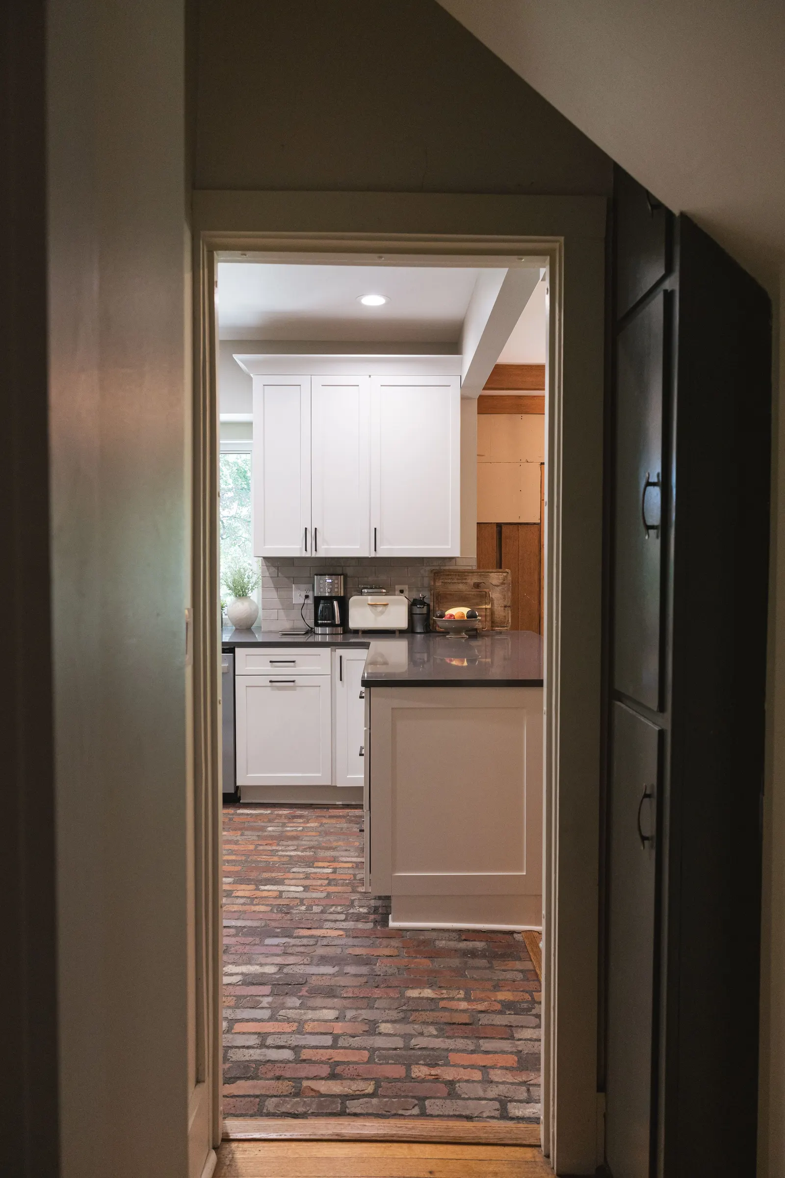 The finished kitchen seen through an original wood-trimmed doorway.