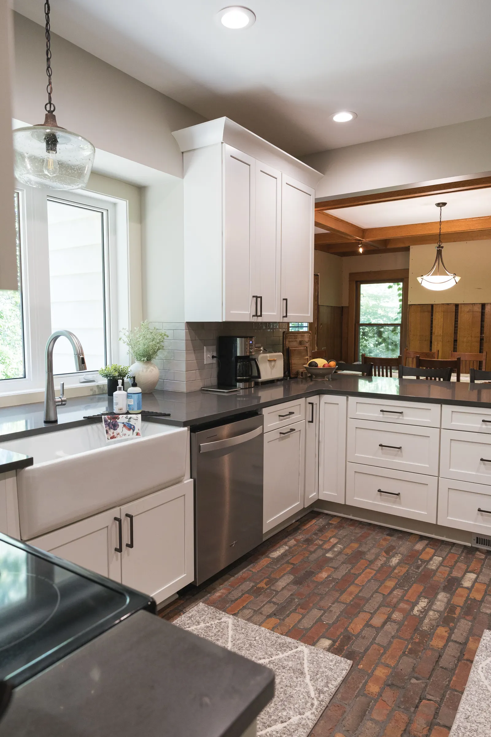 The kitchen and quartz peninsula over the brick floor.