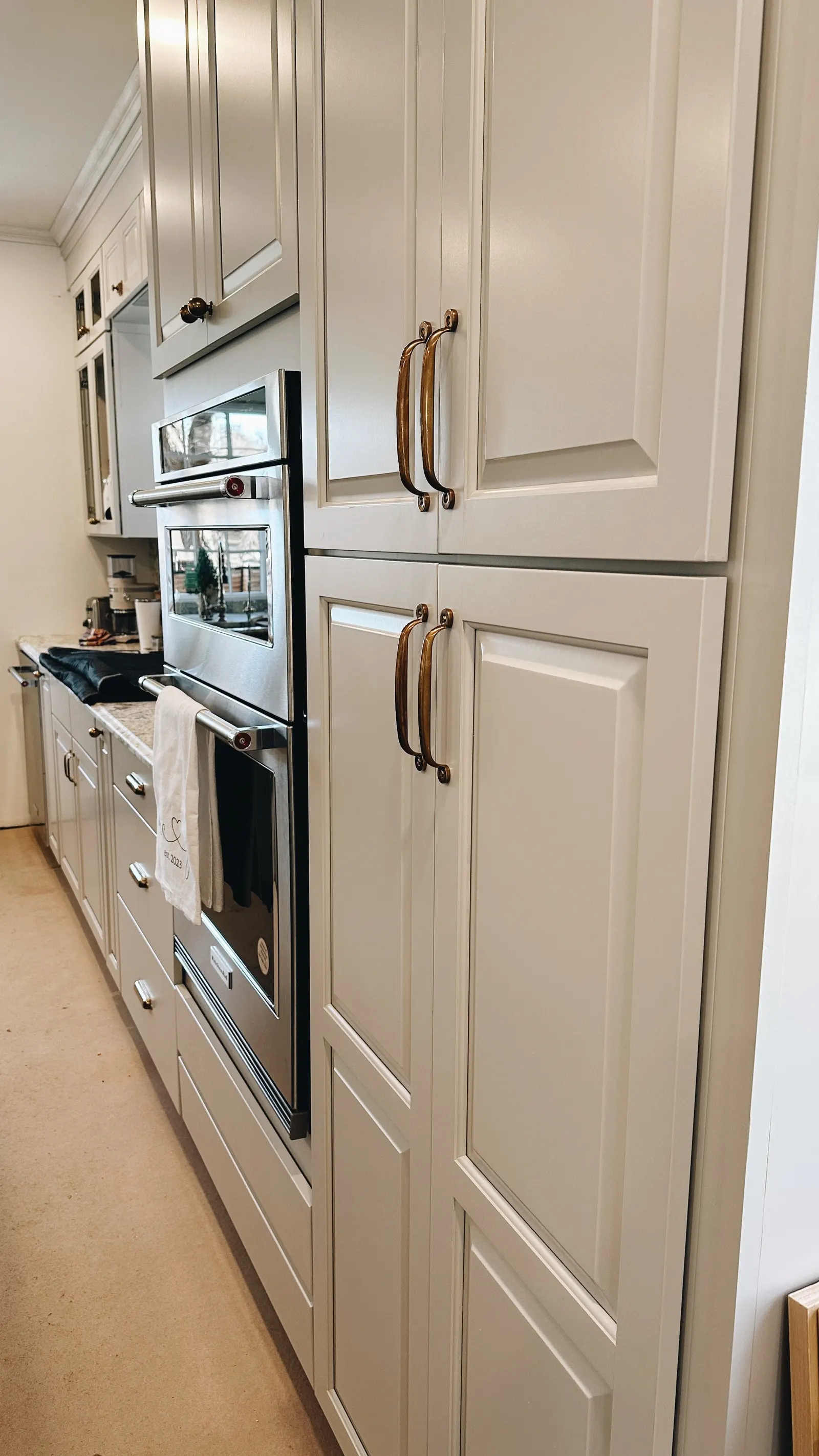 Kitchen with white cabinets, a built-in oven, and a countertop with kitchen appliances.