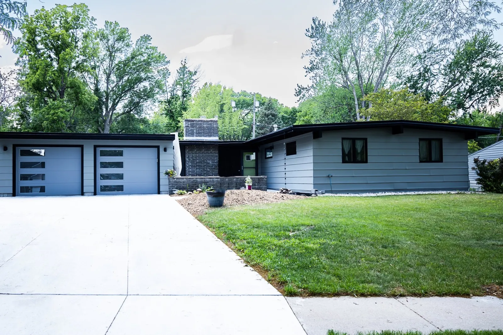 1956 Carport to Garage Transformation, Lincoln Nebraska, professional contractors, craftsmanship, matte black sconces, mid century modern design, gray garage door