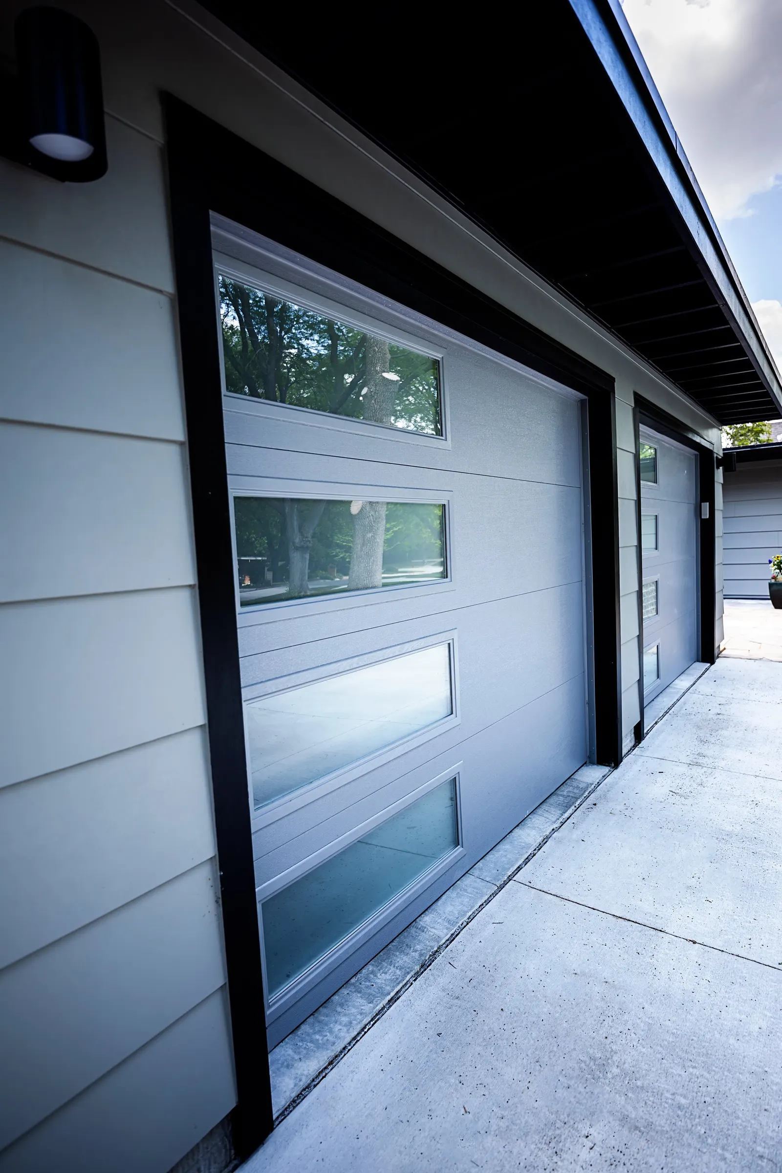 1956 Carport to Garage Transformation, Lincoln Nebraska, professional contractors, craftsmanship, matte black sconces, mid century modern design, gray garage door