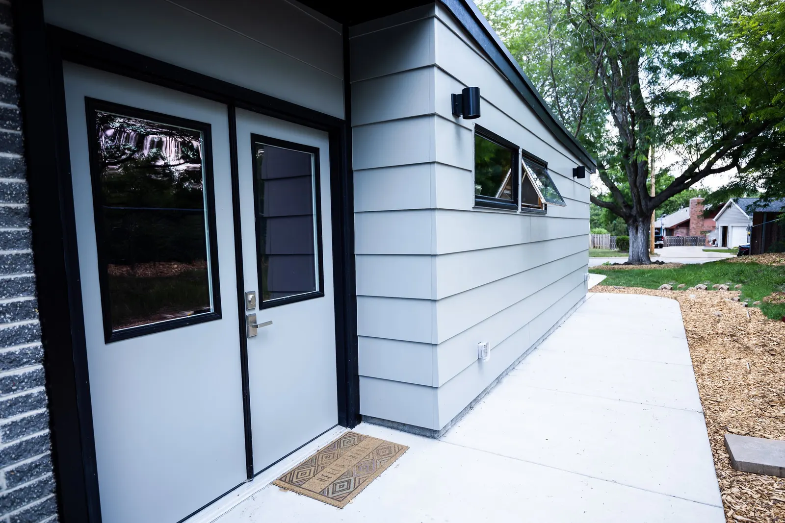 1956 Carport to Garage Transformation, Lincoln Nebraska, professional contractors, craftsmanship, matte black sconces, mid century modern design, gray garage door