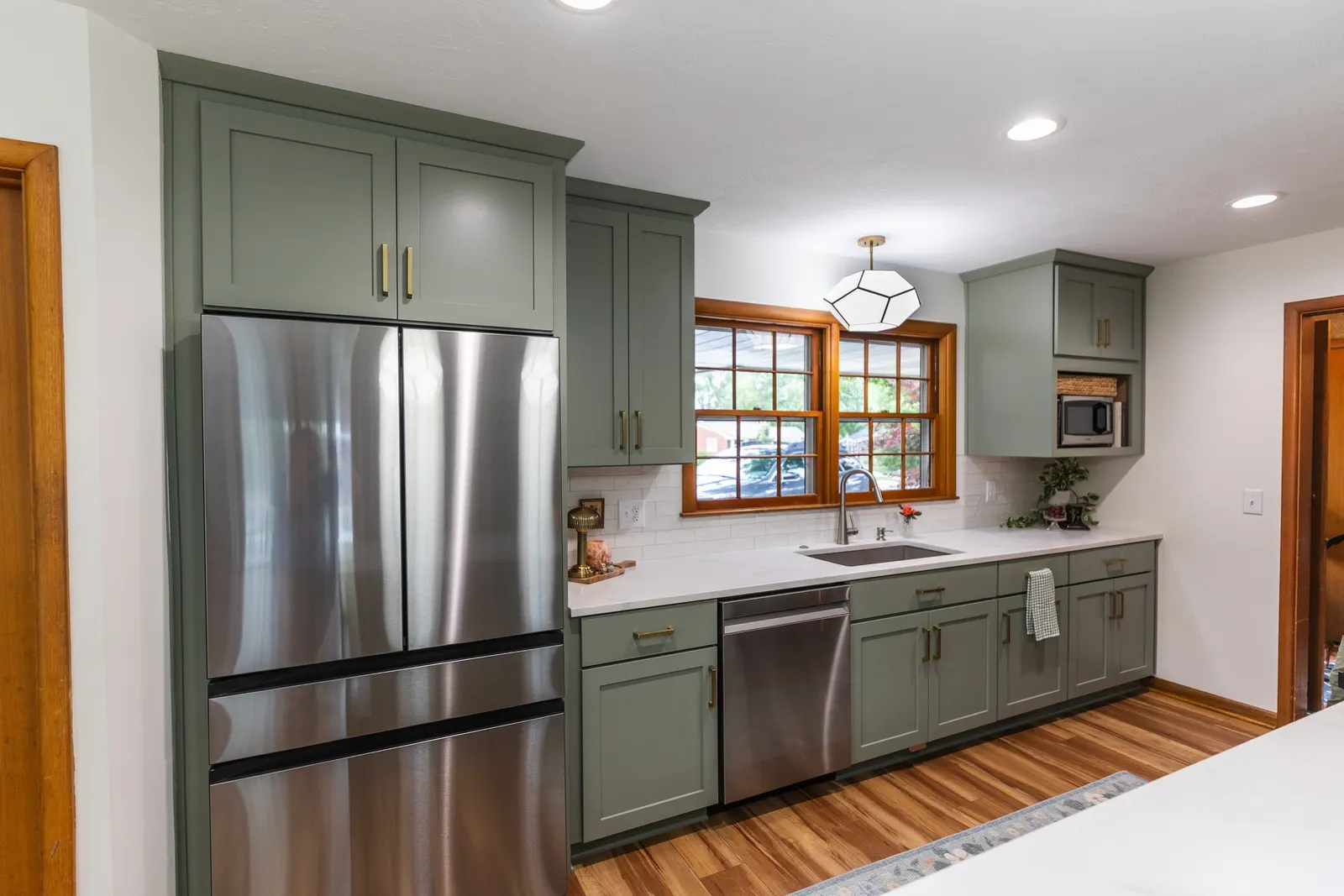 1958 Kitchen Remodel, mid century design, wood floors, stainless steel appliances, sage green cabinets, brushed gold hardware, white quartz countertop, modern light fixtures, Lincoln Nebraska, professional contractors, remodeling and renovations.