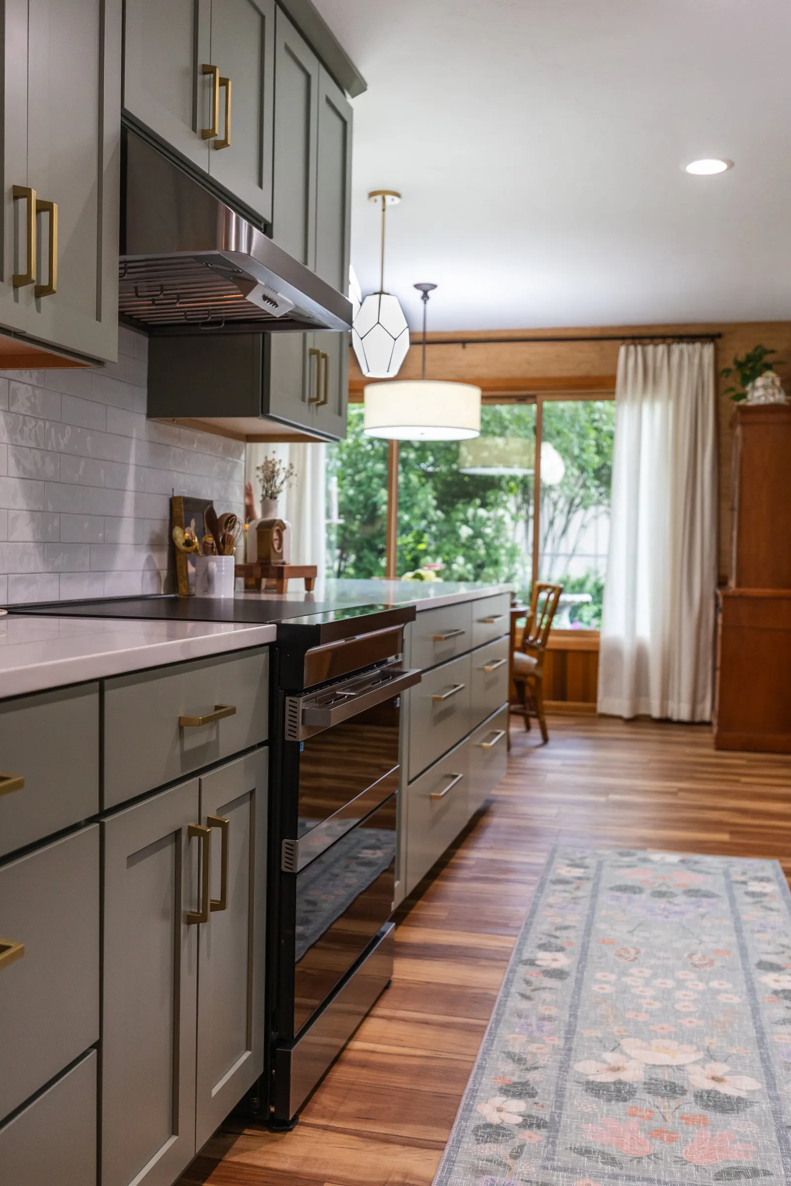 1958 Kitchen Remodel, mid century design, wood floors, stainless steel appliances, sage green cabinets, brushed gold hardware, white quartz countertop, modern light fixtures, Lincoln Nebraska, professional contractors, remodeling and renovations.