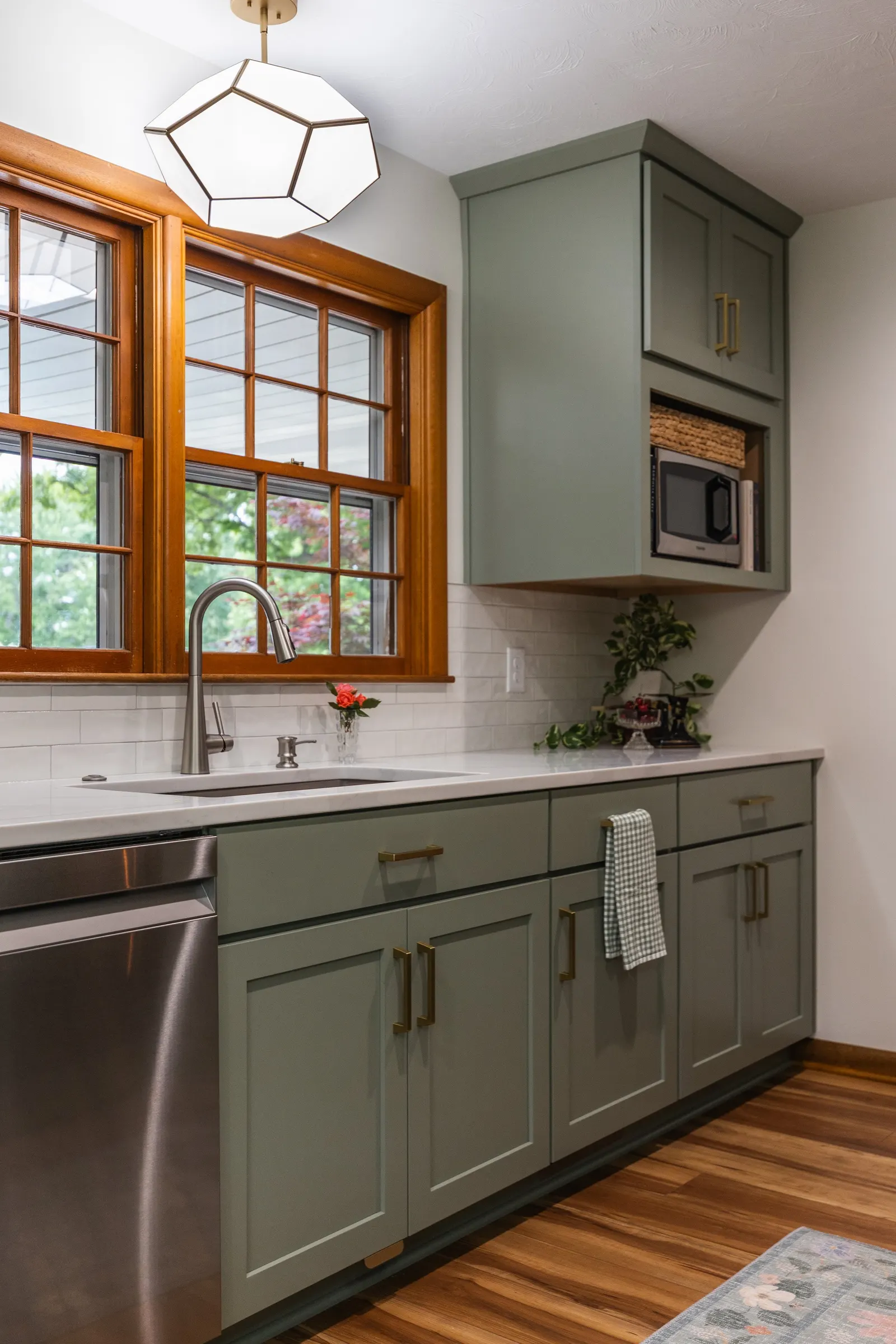 1958 Kitchen Remodel, mid century design, wood floors, stainless steel appliances, sage green cabinets, brushed gold hardware, white quartz countertop, modern light fixtures, Lincoln Nebraska, professional contractors, remodeling and renovations.