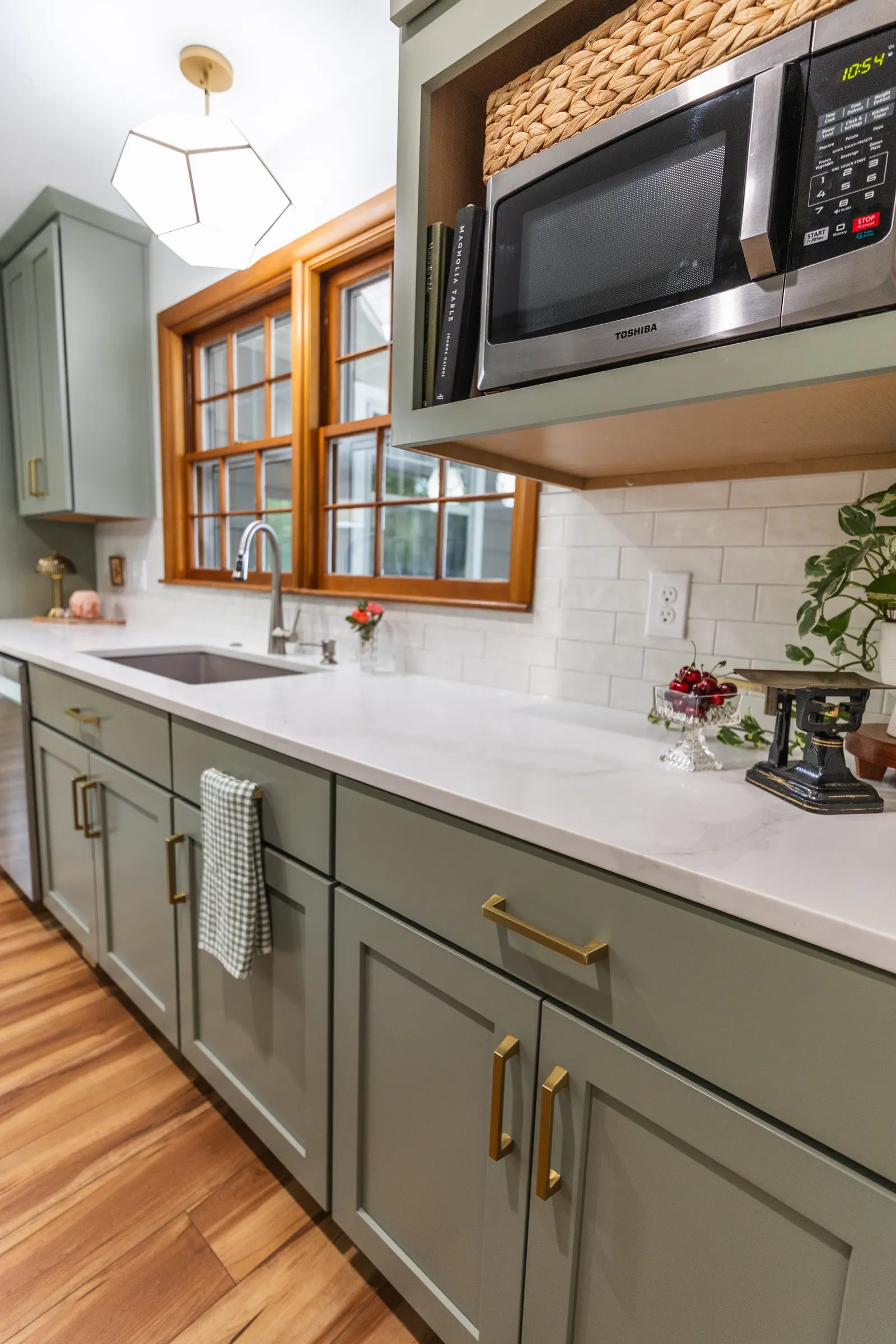1958 Kitchen Remodel, mid century design, wood floors, stainless steel appliances, sage green cabinets, brushed gold hardware, white quartz countertop, modern light fixtures, Lincoln Nebraska, professional contractors, remodeling and renovations.