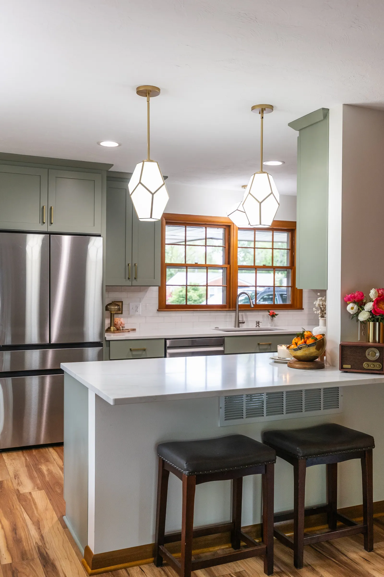 1958 Kitchen Remodel, mid century design, wood floors, stainless steel appliances, sage green cabinets, brushed gold hardware, white quartz countertop, modern light fixtures, Lincoln Nebraska, professional contractors, remodeling and renovations.
