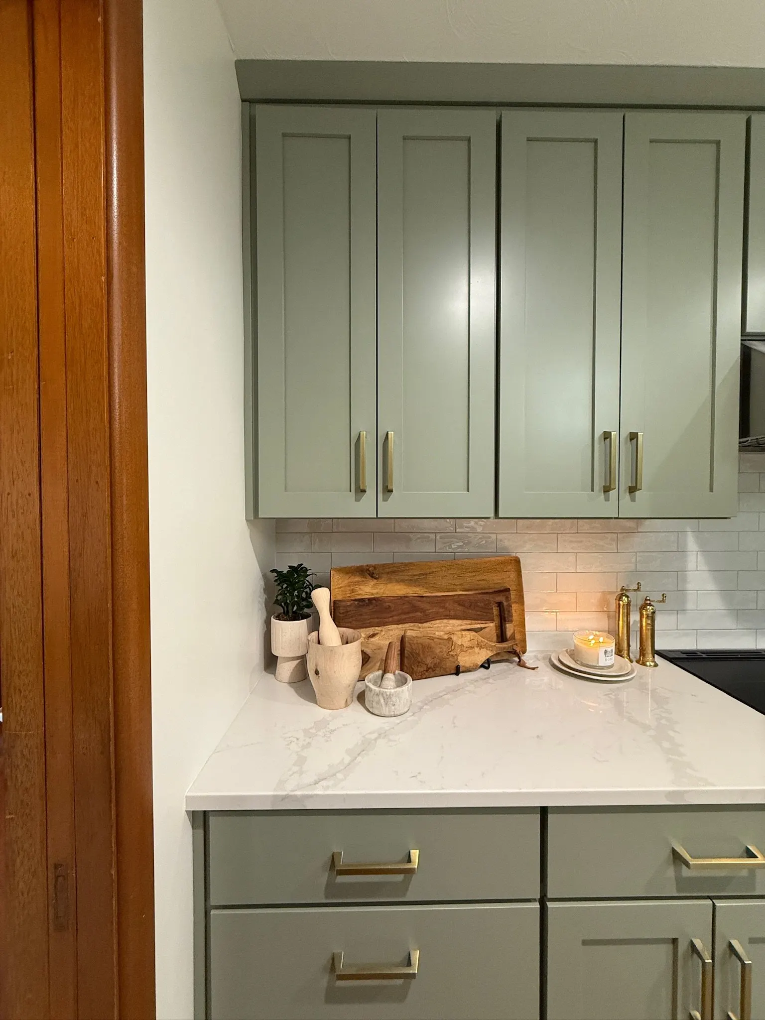 1958 Kitchen Remodel, mid century design, wood floors, stainless steel appliances, sage green cabinets, brushed gold hardware, white quartz countertop, modern light fixtures, Lincoln Nebraska, professional contractors, remodeling and renovations.