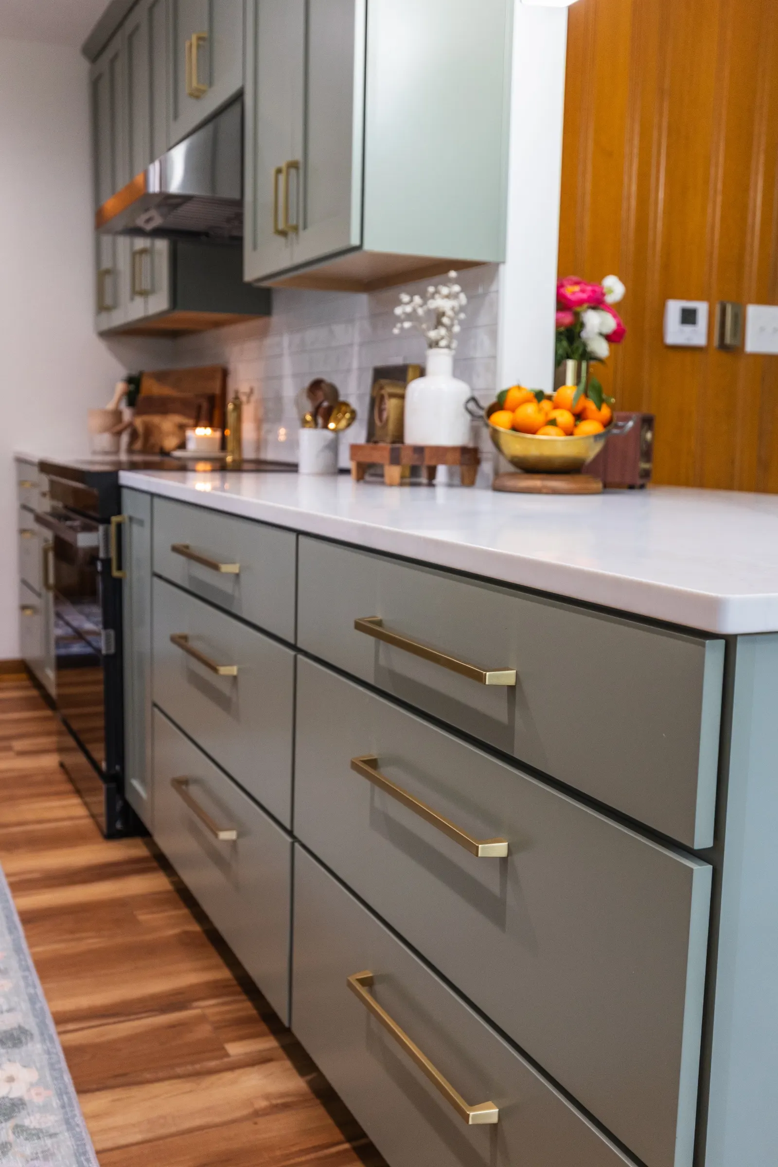1958 Kitchen Remodel, mid century design, wood floors, stainless steel appliances, sage green cabinets, brushed gold hardware, white quartz countertop, modern light fixtures, Lincoln Nebraska, professional contractors, remodeling and renovations.