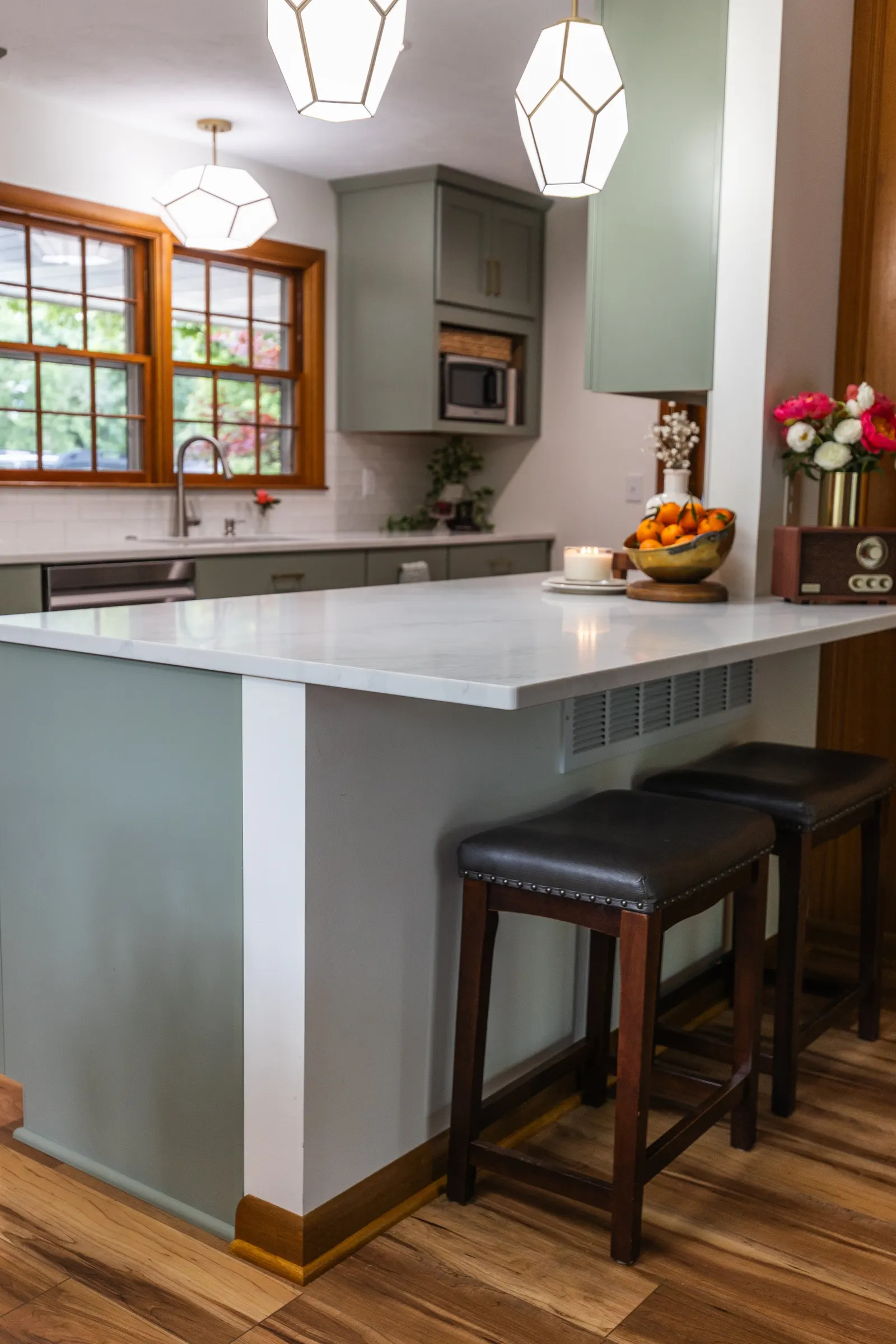 1958 Kitchen Remodel, mid century design, wood floors, stainless steel appliances, sage green cabinets, brushed gold hardware, white quartz countertop, modern light fixtures, Lincoln Nebraska, professional contractors, remodeling and renovations.