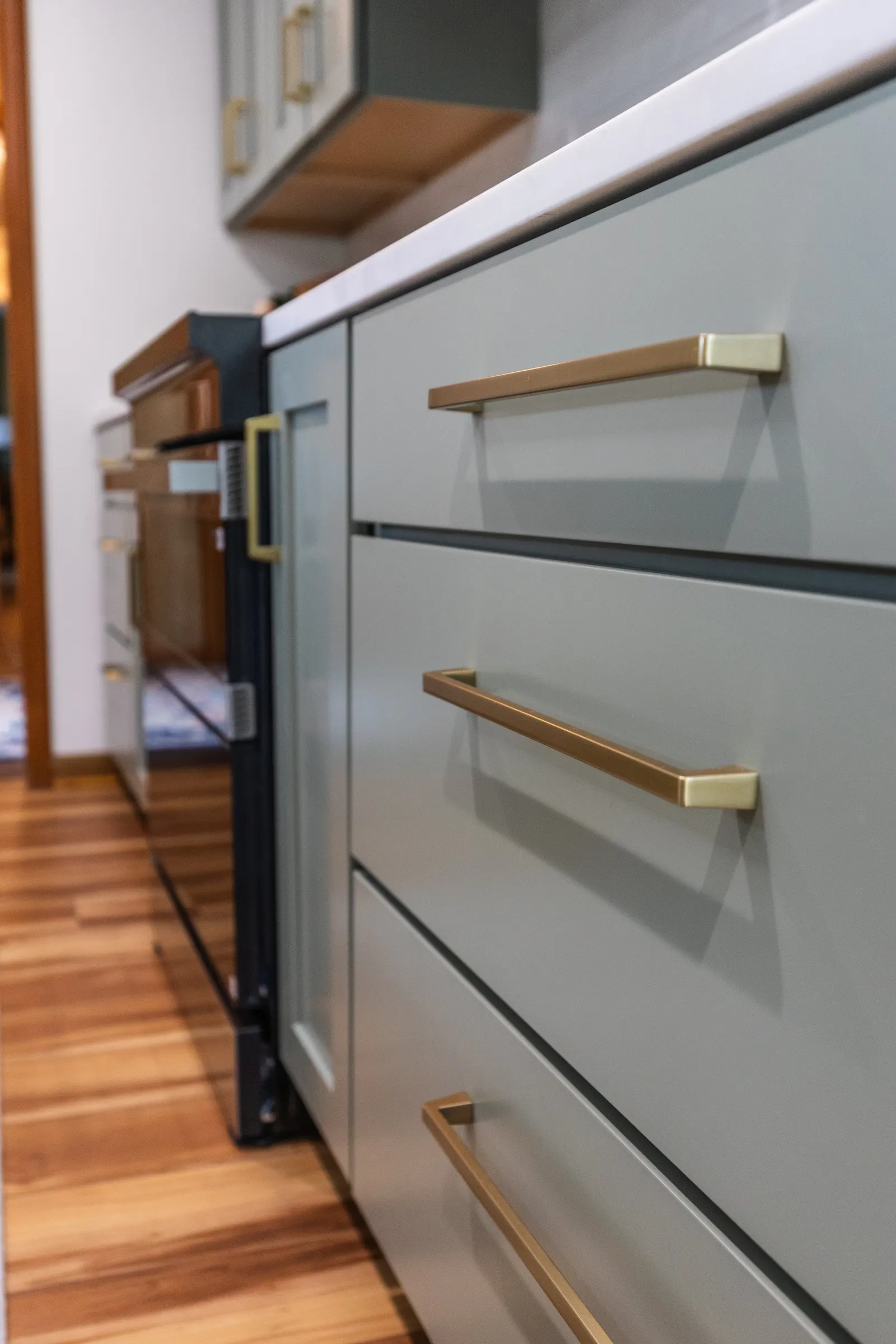 1958 Kitchen Remodel, mid century design, wood floors, stainless steel appliances, sage green cabinets, brushed gold hardware, white quartz countertop, modern light fixtures, Lincoln Nebraska, professional contractors, remodeling and renovations.