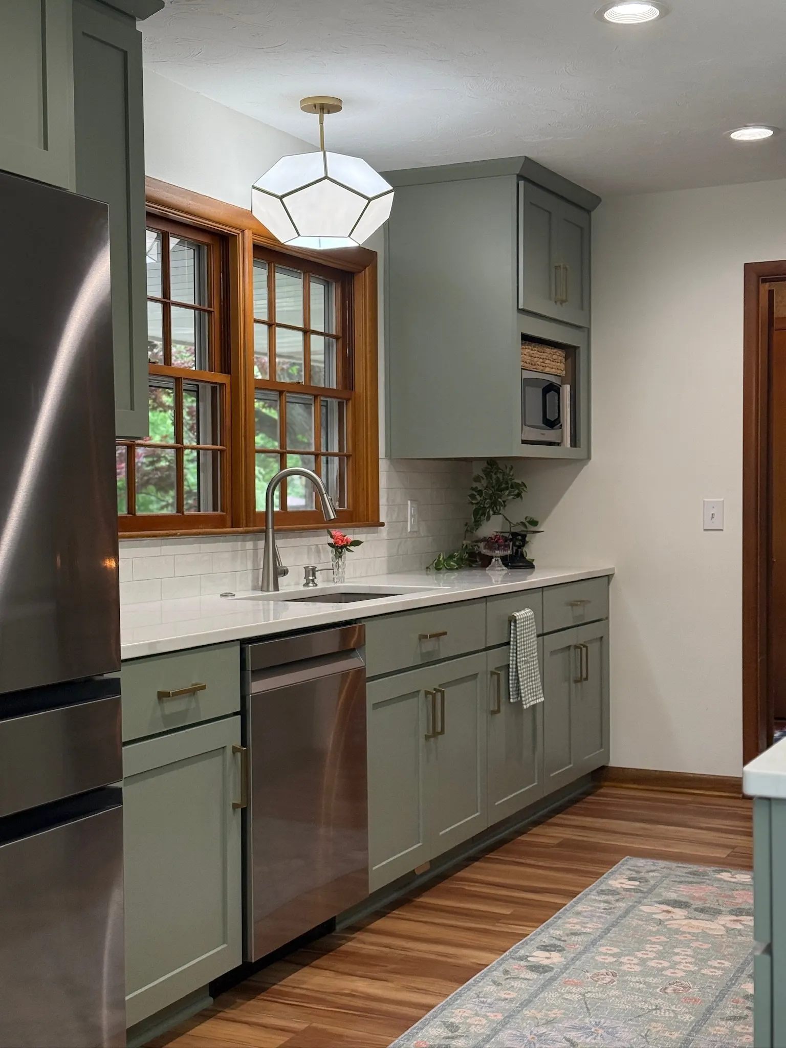 1958 Kitchen Remodel, mid century design, wood floors, stainless steel appliances, sage green cabinets, brushed gold hardware, white quartz countertop, modern light fixtures, Lincoln Nebraska, professional contractors, remodeling and renovations.