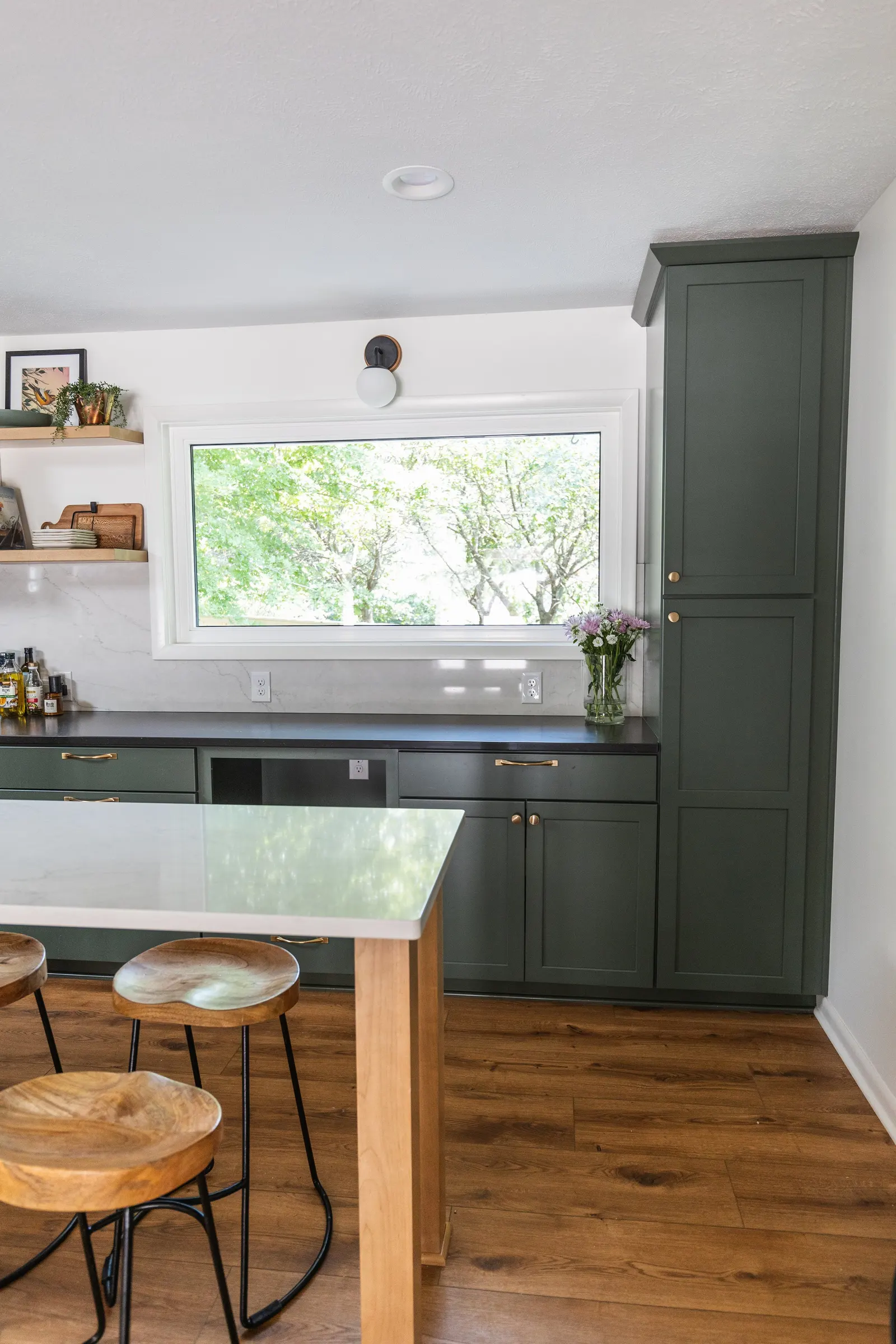 1962 Kitchen Remodel, dark green cabinets, white quartz island, wooden floors, brass hardware, wood cabinets, custom hood, floating shelves, dark countertops, open shelving