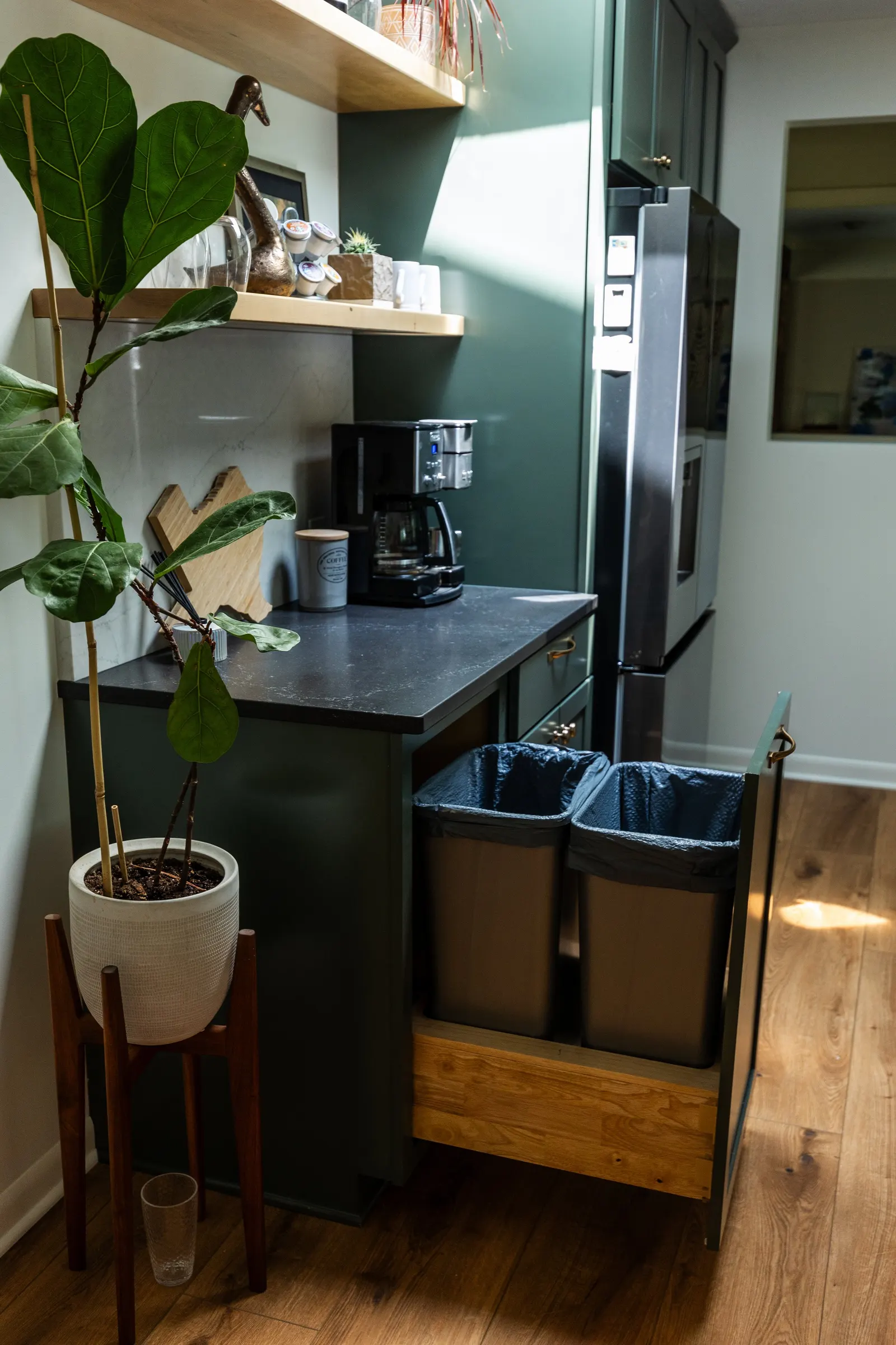 1962 Kitchen Remodel, dark green cabinets, white quartz island, wooden floors, brass hardware, wood cabinets, custom hood, floating shelves, dark countertops, open shelving, large windows, craftsmanship, custom cabinets.