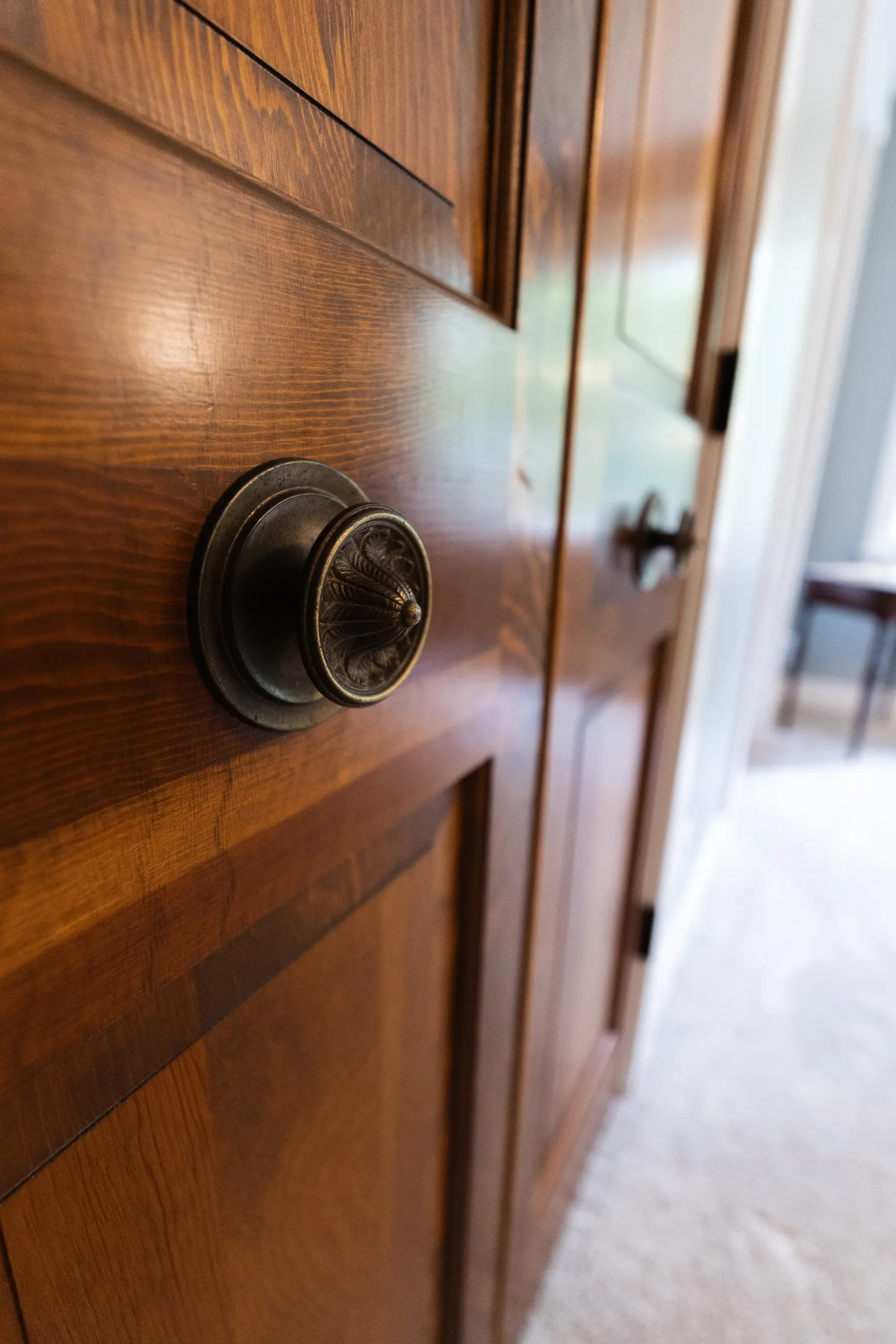 Close-up of a vintage brass doorknob on a wooden door, with other similar doors visible in the background.