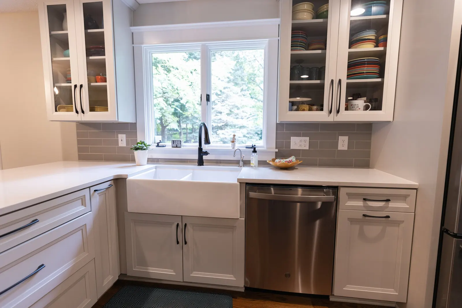 1974 Whole Home Remodel, kitchen remodel, wood floors, quartz countertop, craftsmanship, farmhouse style, custom hood, white cabinets, matte black hardware, farmhouse sink, pendant lights, large island, dual tone kitchen, large windows, patio doors.