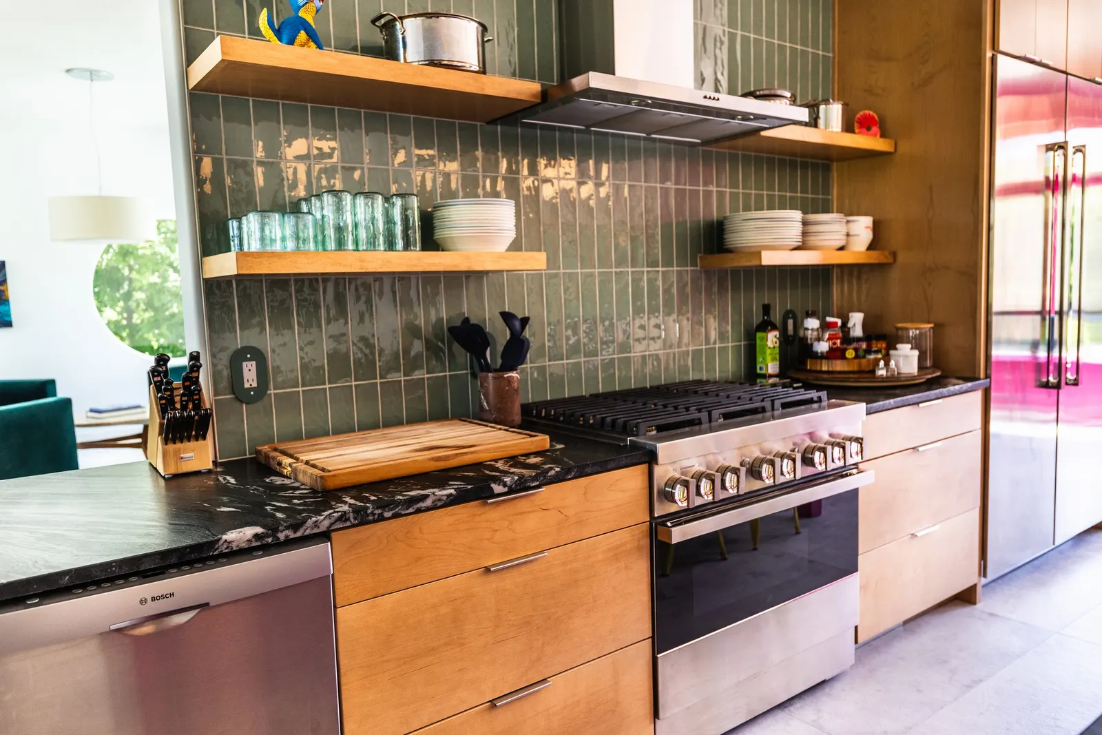 2007 Kitchen Remodel, vibrant pink accents, green tile backsplash, wooden cabinets, brushed nickel hardware, quartz countertop, large island, pendant lights, open shelving, floating shelves, tile floor, coffee bar, wallpaper, eat in kitchen, addition