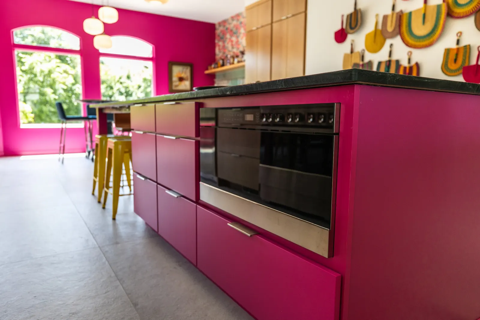 2007 Kitchen Remodel, vibrant pink accents, green tile backsplash, wooden cabinets, brushed nickel hardware, quartz countertop, large island, pendant lights, open shelving, floating shelves, tile floor, coffee bar, wallpaper, eat in kitchen, addition