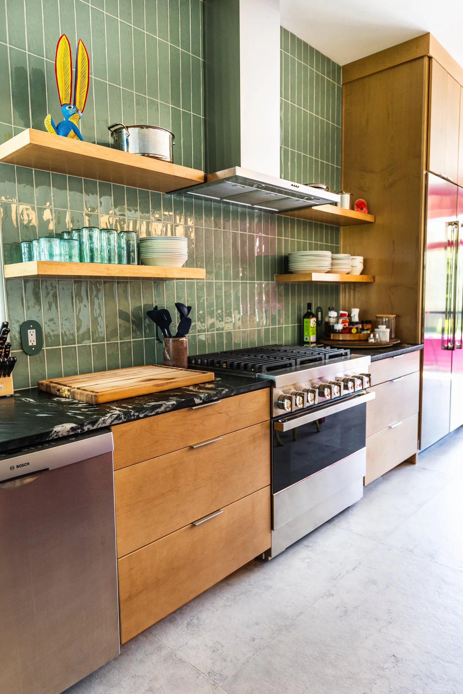 2007 Kitchen Remodel, vibrant pink accents, green tile backsplash, wooden cabinets, brushed nickel hardware, quartz countertop, large island, pendant lights, open shelving, floating shelves, tile floor, coffee bar, wallpaper, eat in kitchen, addition