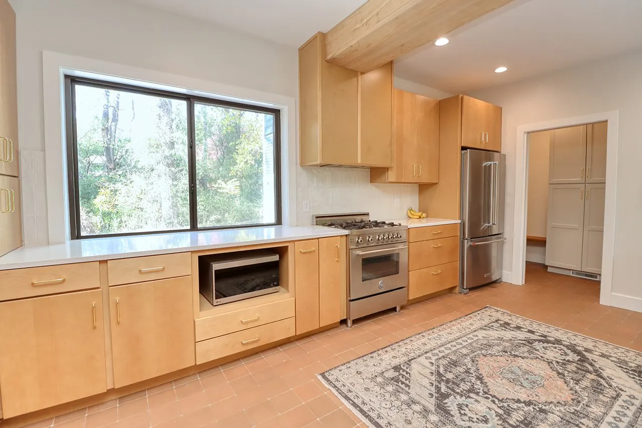 Forest House Kitchen Remodel, Whole Home Remodel, gold hardware, boho chic, farmhouse sink, custom hood, custom wood cabinets, tile floor, stainless steel appliances, white quartz countertops, large windows, wood beams, craftsmanship.