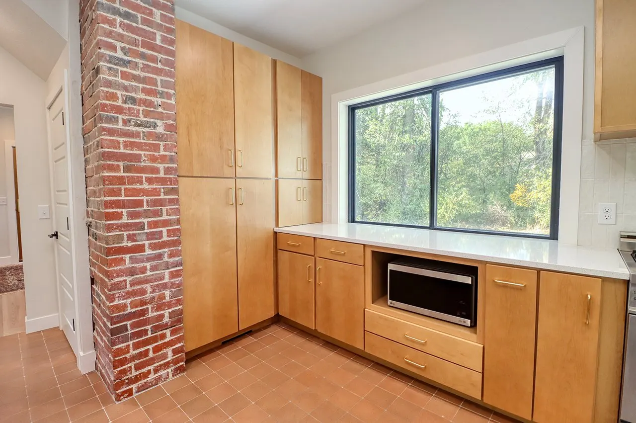 Forest House Kitchen Remodel, Whole Home Remodel, gold hardware, boho chic, farmhouse sink, custom hood, custom wood cabinets, tile floor, stainless steel appliances, white quartz countertops, large windows, wood beams, craftsmanship, brick accents.