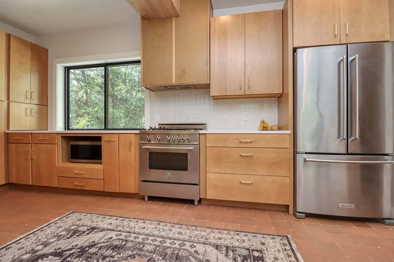 Forest House Kitchen Remodel, Whole Home Remodel, gold hardware, boho chic, farmhouse sink, custom hood, custom wood cabinets, tile floor, stainless steel appliances, white quartz countertops, large windows, wood beams, craftsmanship, brick accents.