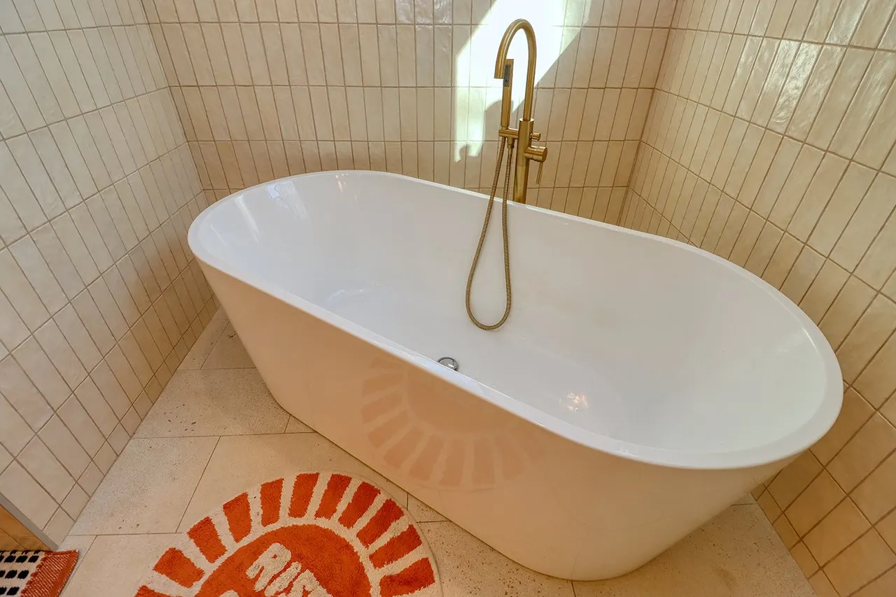 Forest House Remodel, whole home remodel, primary en-suite, free standing bathtub, walk-in shower, tile floor, large windows, mid century modern design, wood vanity, white quartz countertops, brass fixtures, custom vanity.