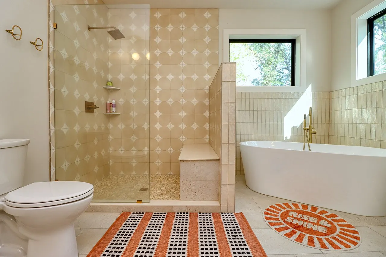 Forest House Remodel, whole home remodel, primary en-suite, free standing bathtub, walk-in shower, tile floor, large windows, mid century modern design, wood vanity, white quartz countertops, brass fixtures, custom vanity.